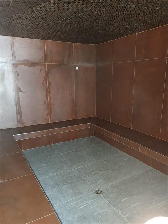 Hammam terminé avec sol en pierre grise et banquette carrelée