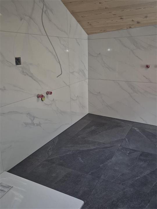 Salle de bain sous les combles : murs effet marbre et sol grand format effet ardoise